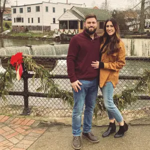 A happy couple poses near holiday decor, with Xpress Construction & Services office shown in the Mentor, OH background.
