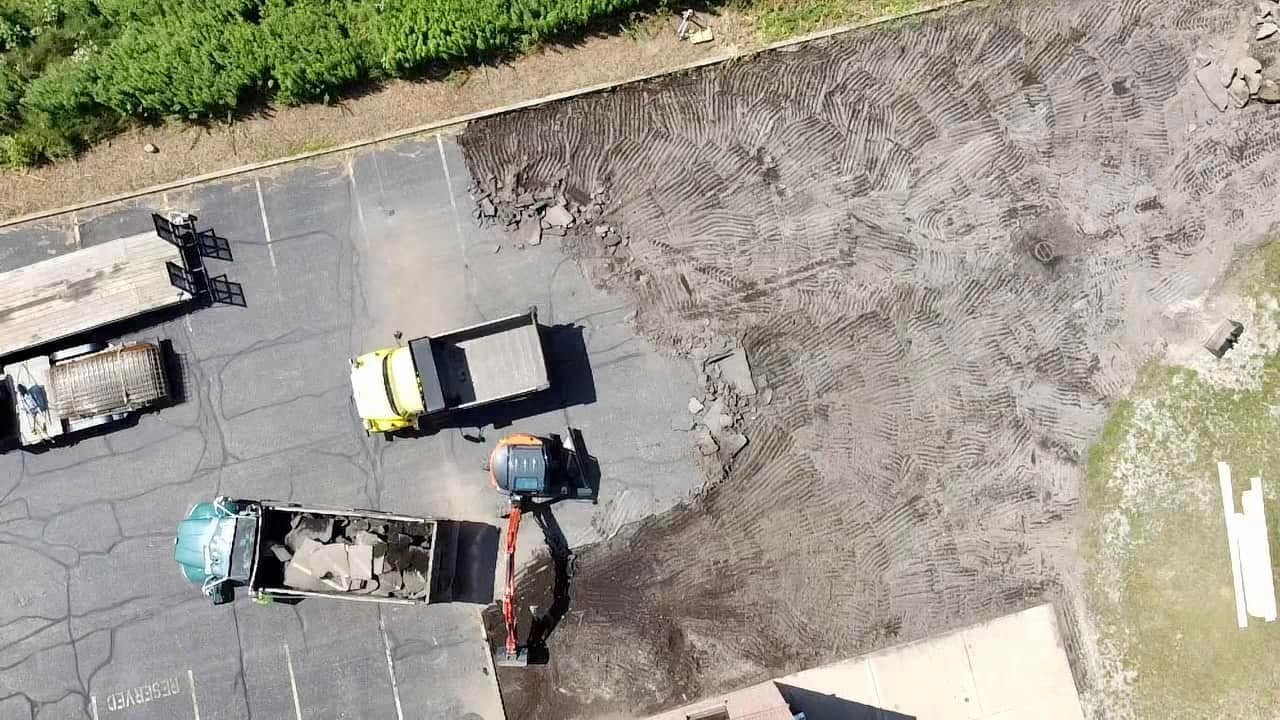 Xpress Construction & Services is building a new parking lot with heavy equipment and workers preparing the area for use.